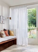 Orford White Voile curtains dressing modern french doors leading to a garden