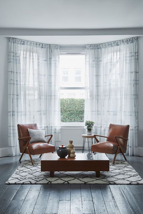 Adrift Ink Wash Voile Curtains in 3 sided bay window with tan armchairs