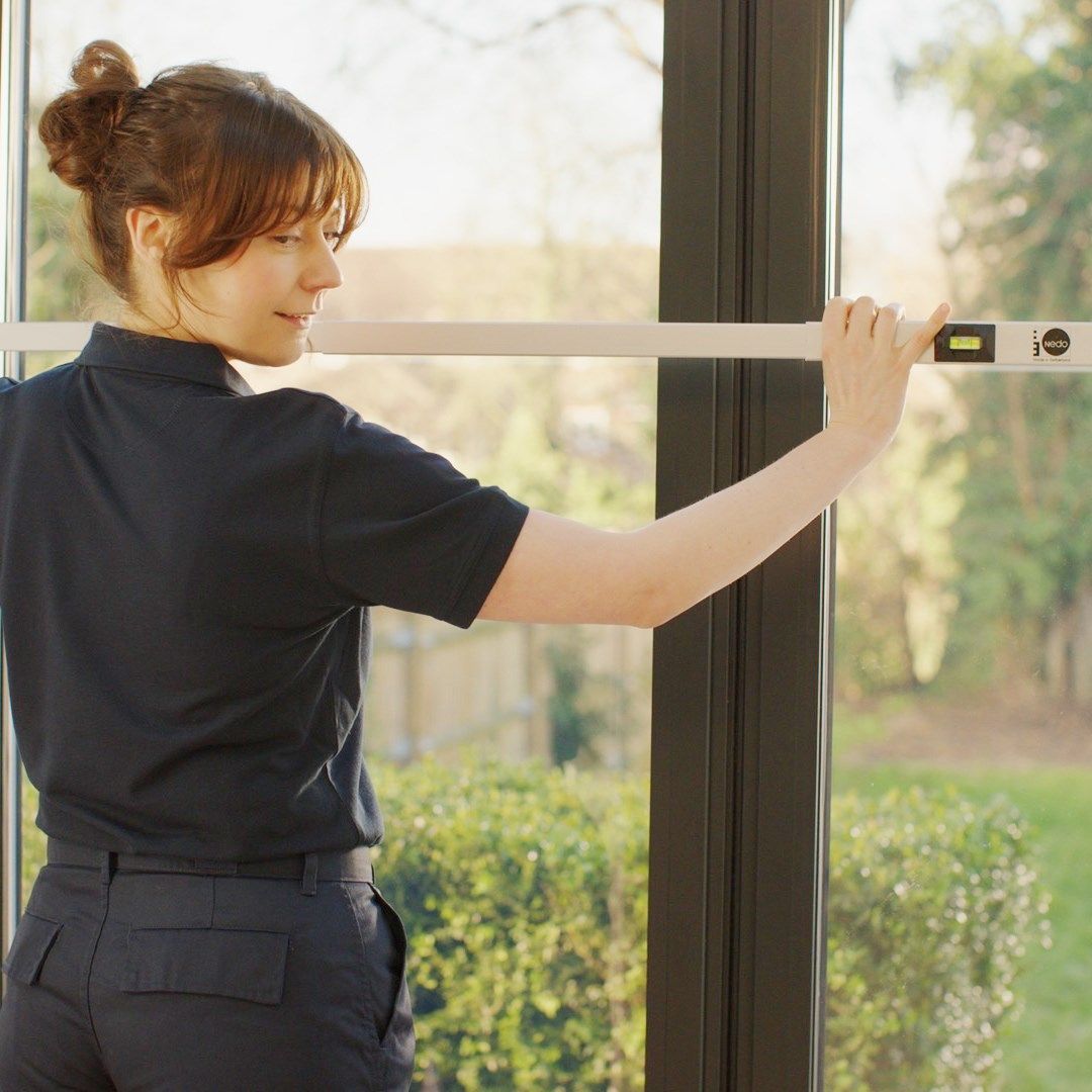 A specialist installer measuring a window