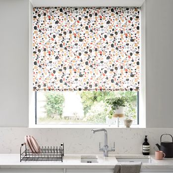 Lucca Brick Roller blind in a kitchen window with chrome accessories 