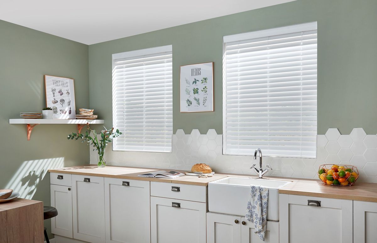 white faux wood wooden blinds fitted to two windows in a kitchen setting