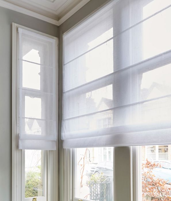 serenity white voile roman blinds in a box bay living room window