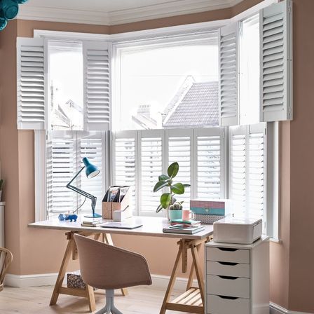 Richmond ice white tier on tier shutters in large upstairs bay window of pastel coloured home office
