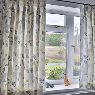 cream, floral print, pencil pleat curtains in a bright room