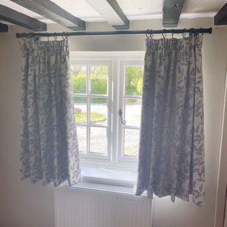 Taupe curtains with a navy floral print in a cosy cottage