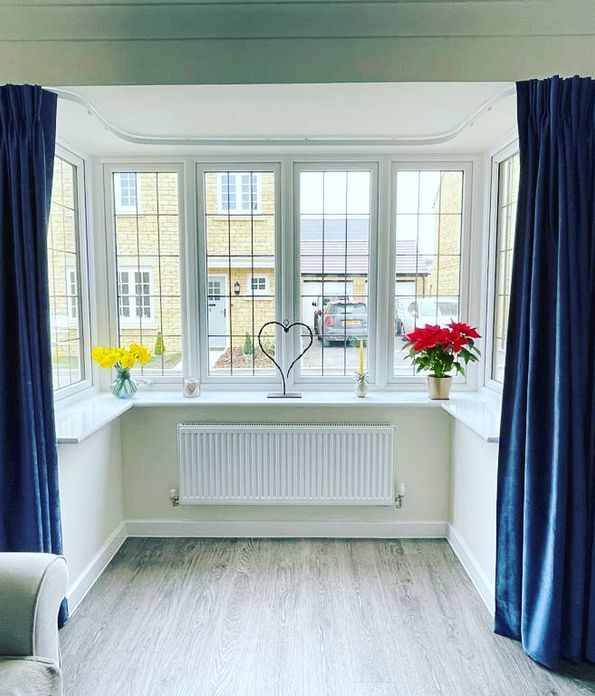 Deep Blue bay window curtains in a bright living room 