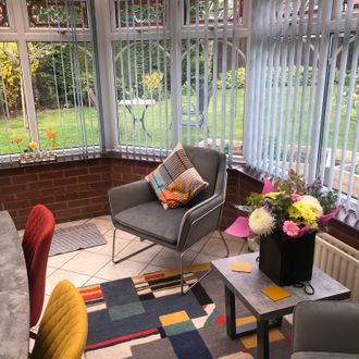 Grey vertical blinds in a colourful conservatory