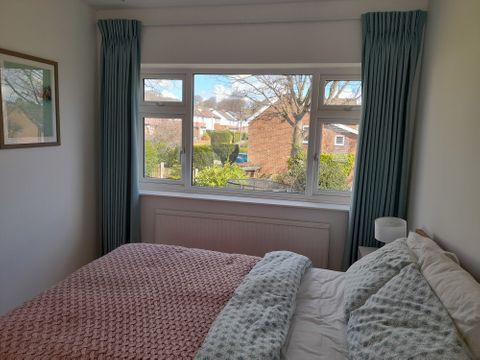 Customer Lucy Peers pinch pleat blue curtains in large bedroom window