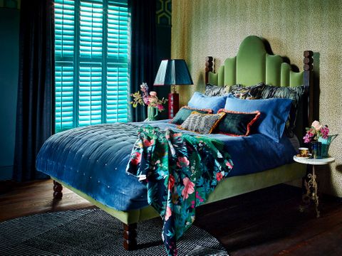 Dark and moody bedroom design with luxurious dark blue velvet curtains