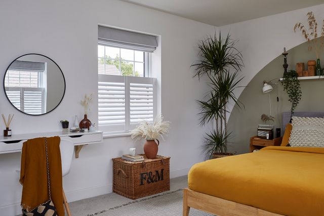 White cafe shutters in a bright bedroom