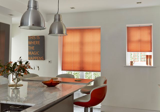 Red/peach coloured pleated blind in large and small windows of open plan kitchen diner 