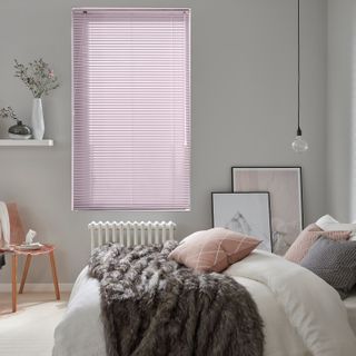 muted pink metal venetian blinds in a cosy, neutral bedroom