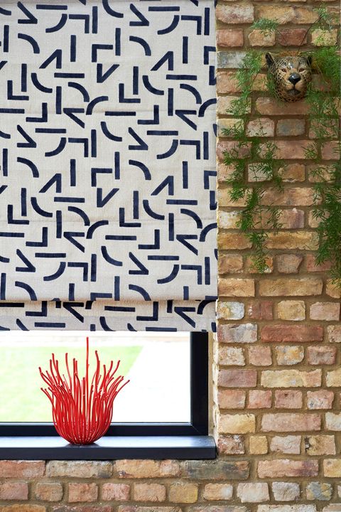 Mori Navy Roman blind fitted to a window with exposed brick walls