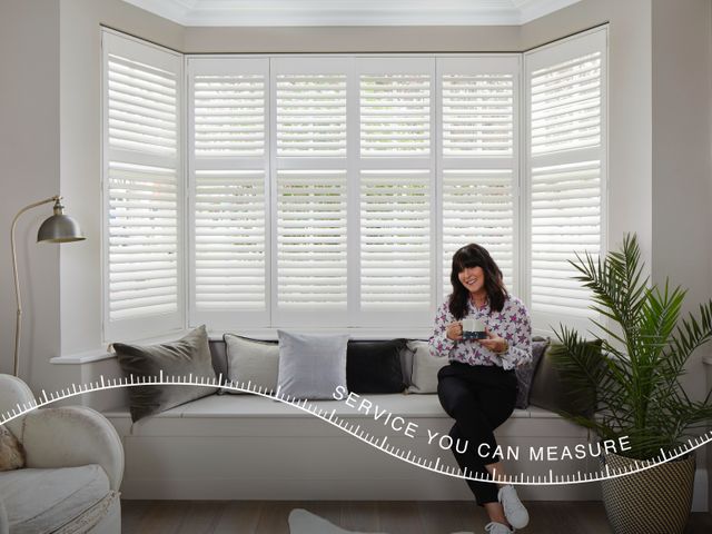 white shutters in a modern living room with an overlay saying: service you can measure