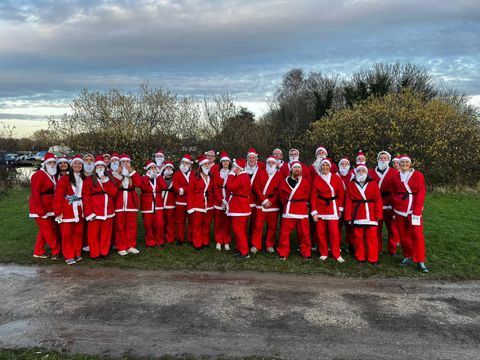 Group of people dressed as Santa go for walk/run