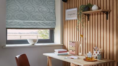 Tranquil Mineral roman blind with Collette Minx fringing in an office window