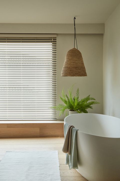 Zen Whisper faux wood venetian blind in a bedroom window with a bath. 