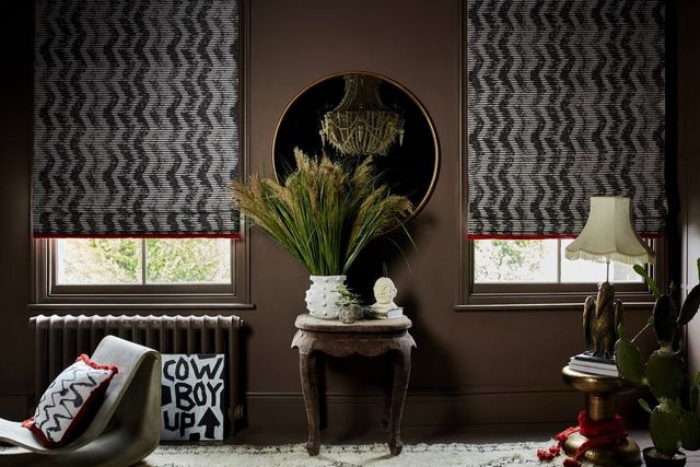 black and white zig zag patterned roman blinds fitted to two tall large windows in a living room