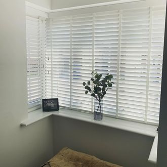 White Wooden blinds in bay window