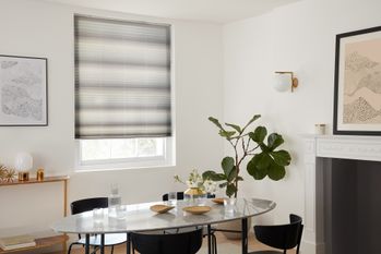 grey pleated blinds fitted to a window in a white decorated dining room