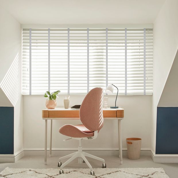 Faux wood venetian blinds with tapes in granite light grey shade on a home office window