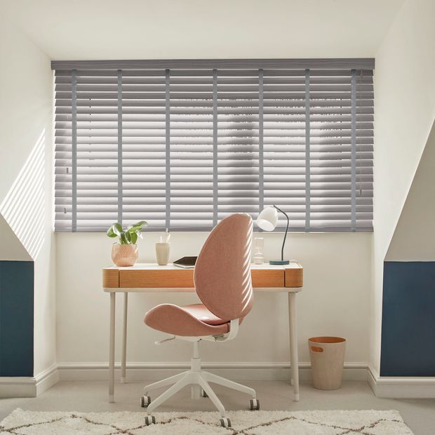 Faux wood venetian blinds with tapes in smoke graphite shade on a home office window