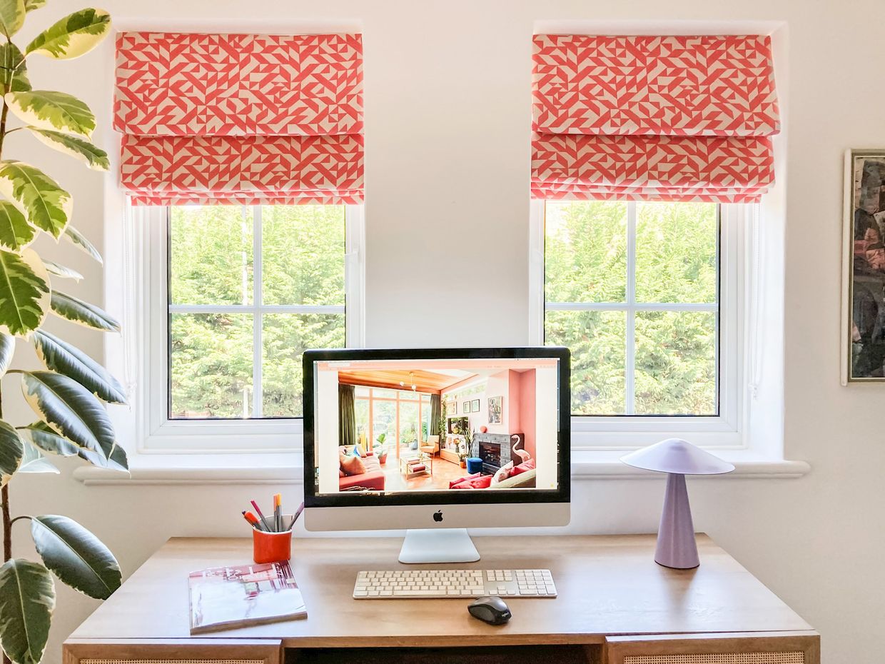 Terrazzo Coral roman blinds in an home office with a desk in front of the windows with a computer on it