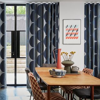 Navy and silver patterned floor to ceiling curtains fitted to a door window in a dining room