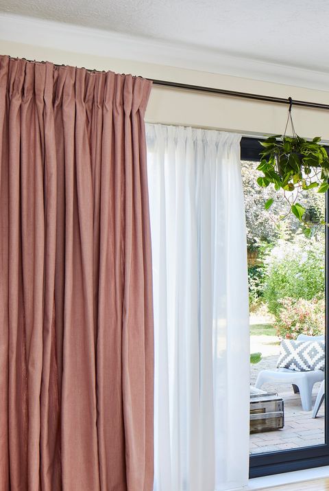 Close up of pink curtains over white voile curtains on a large window
