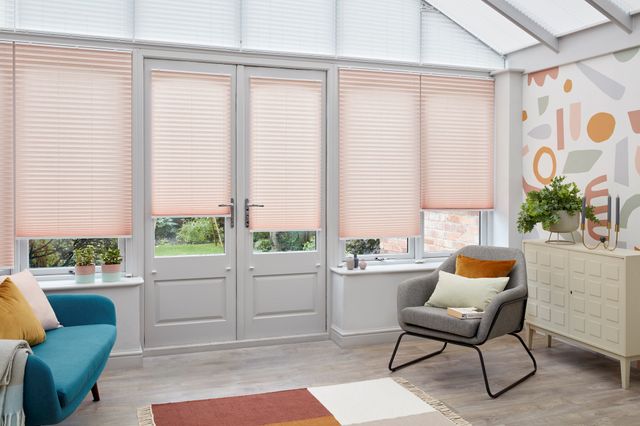 High Grove white pleated blinds and Crush Blush pink pleated fitted to windows in a conservatory setting