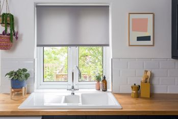reber ash roller blind in kitchen window above white sink