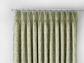 light green curtain with darker green leaf pattern header on a silver curtain pole