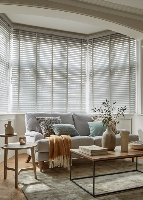 grey coloured wooden blinds fitted to a bay window in a living room