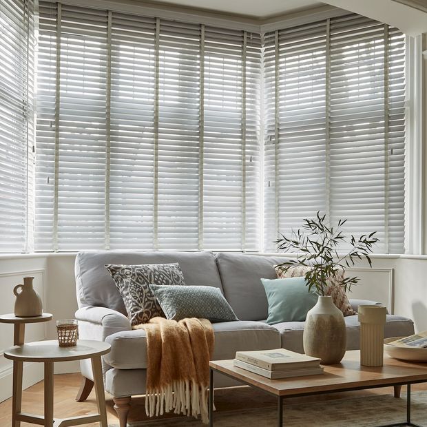 grey coloured wooden blinds fitted to a bay window in a living room