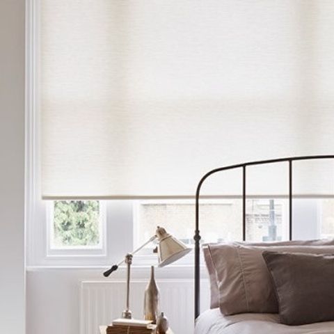 Plain Norfolk Ivory roller blind hung in bedroom