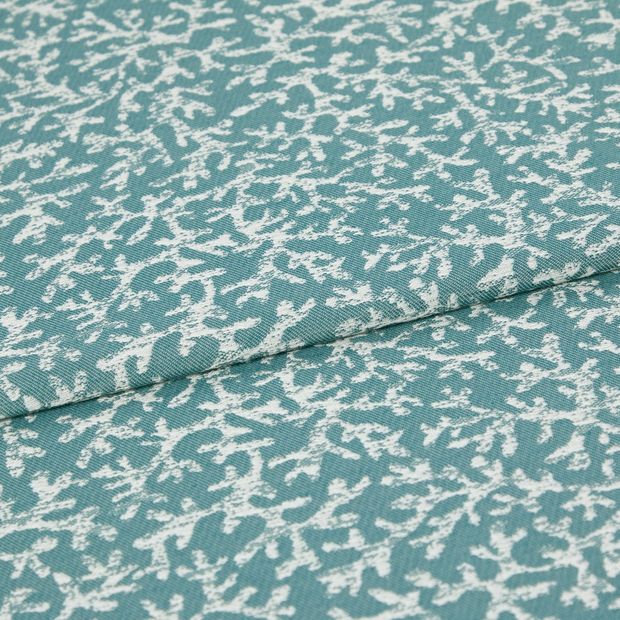 A folded piece of fabric with Coral Pacific Teal printed on it