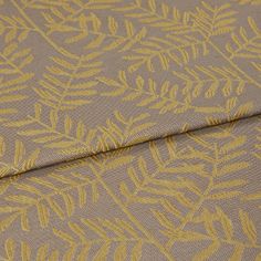 A folded piece of fabric with Fronds Harvest Cream printed on it