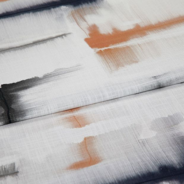 A folded piece of fabric with Expression Canyon Orange printed on it