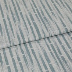 A folded piece of fabric with Flourish Ocean Teal printed on it