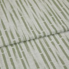 A folded piece of fabric with Flourish Sage Light Green printed on it