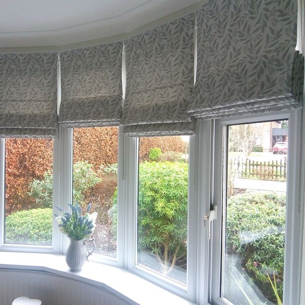 Folia silver roman blinds in curved bay window in living room