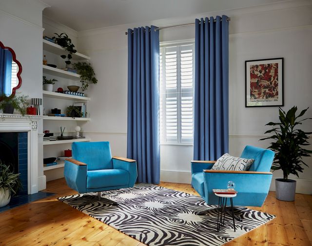 Faso cornflower blue eyelet curtains paired with white shutters in living room