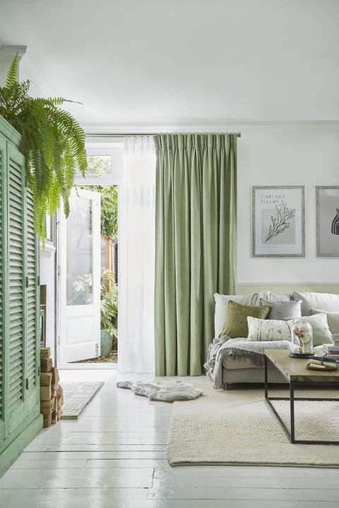 Pearl olive green floor length pinch pleat curtains paired with voiles in cosy living room