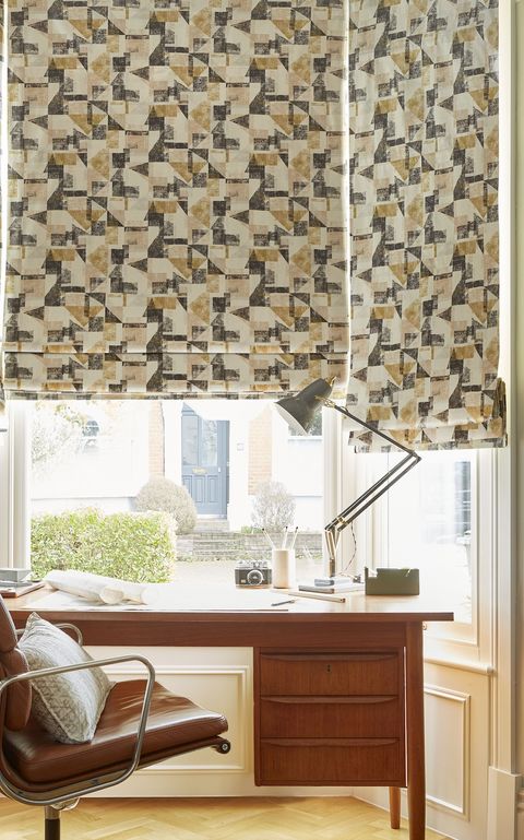 Fraction amber geometric roman blinds on bay window in home office