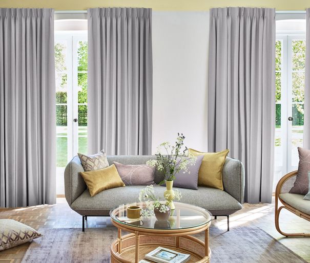 Two sets of bailey lavender fog curtains in open floral themed living room