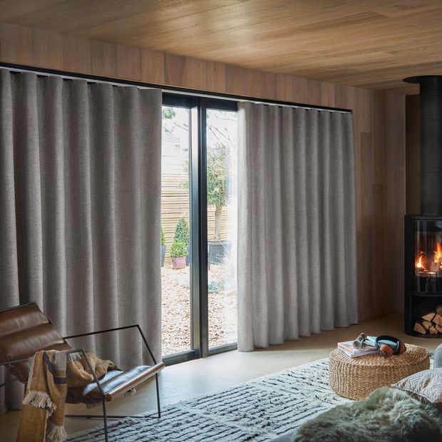 Nest pewter floor length wave curtains on large windows in cosy bedroom with fire