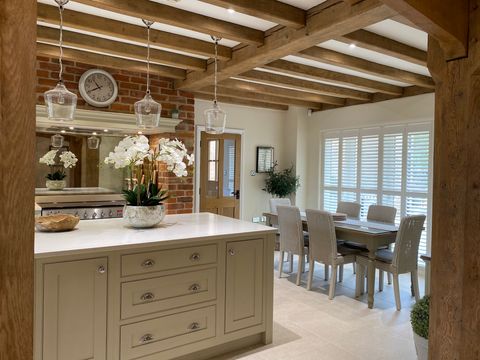 pure white tracked shutters in dining room/kitchen