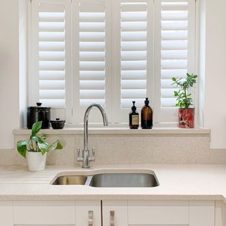 pure white full height shutters on small window in kitchen above sink