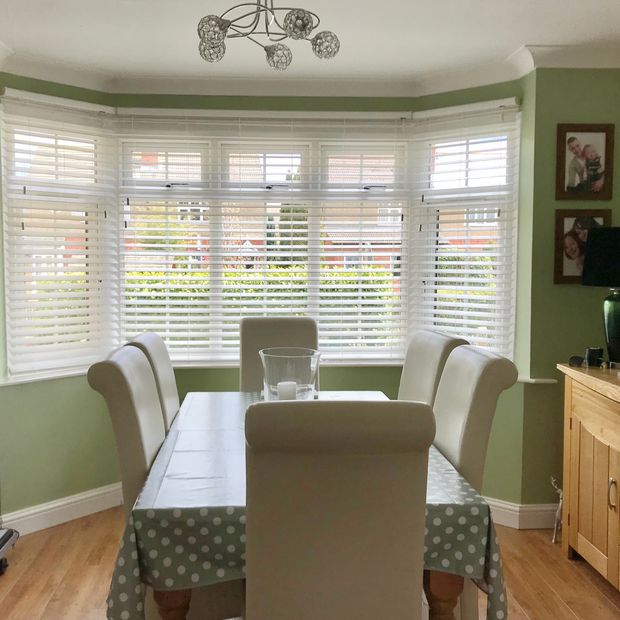 Mirage white maple faux wooden blinds in bay window in dining room