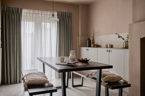grey floor length curtains paired with cream voile curtains in a cosy neutral themed dining area